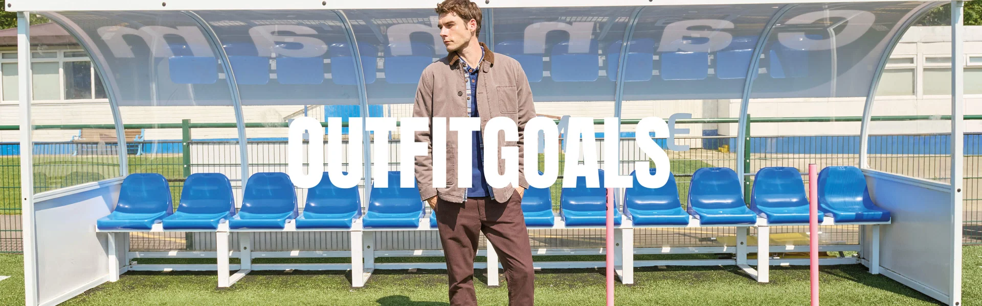 Mann auf dem Fußballfeld in beigefarbener Jacke, darüber der Text ‚Outfit Goals'.